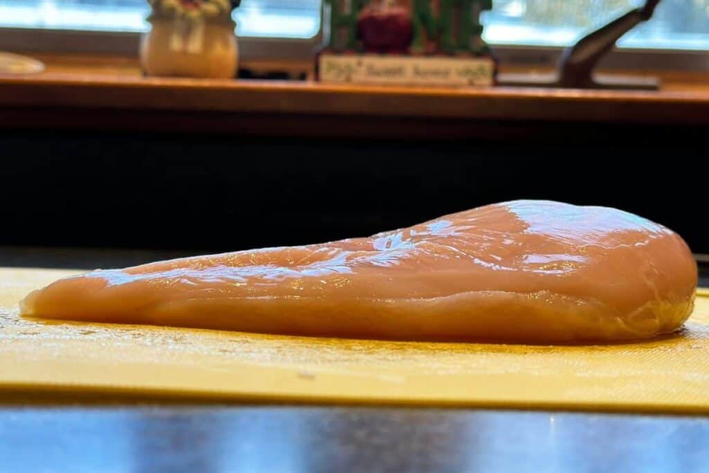 A profile picture of a chicken breast demonstrating how one side is much thicker than the other