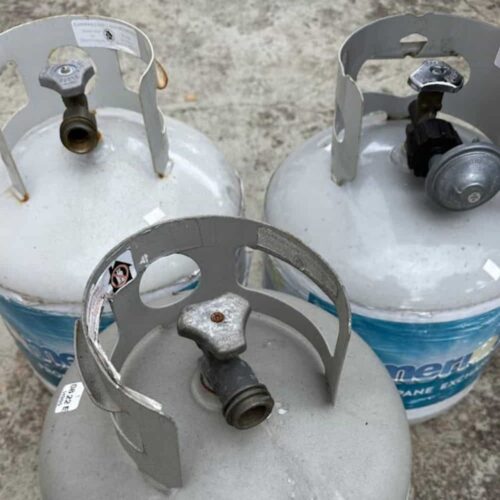 Three propane tanks sitting on a patio