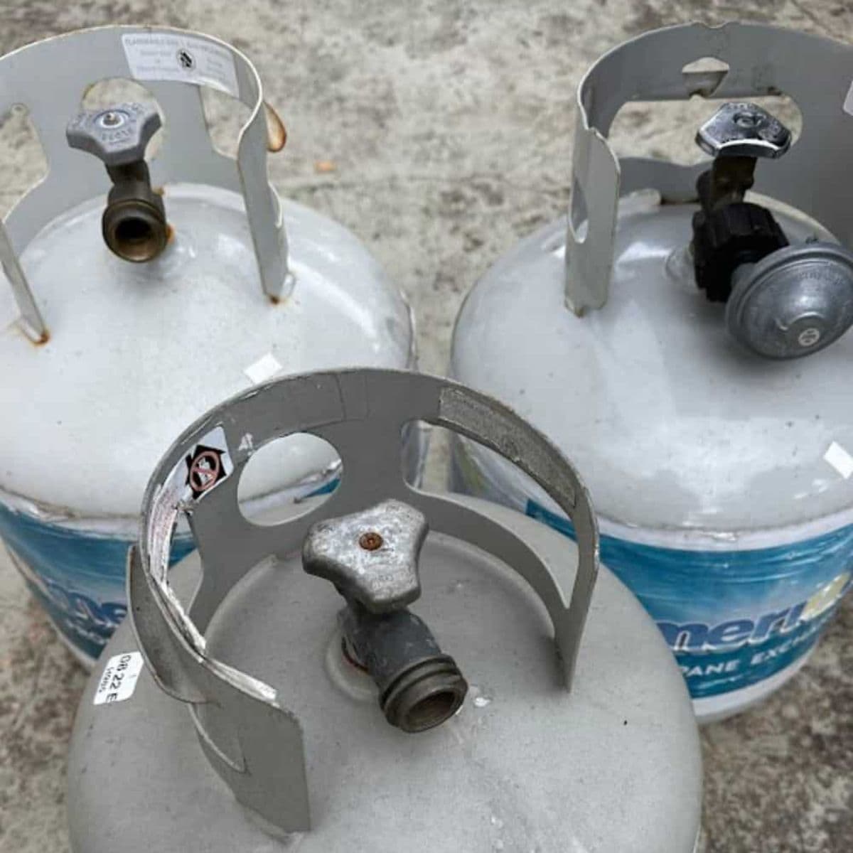 Three propane tanks sitting on a patio