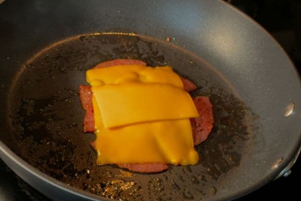 Taylor ham and cheese cooking in a pan