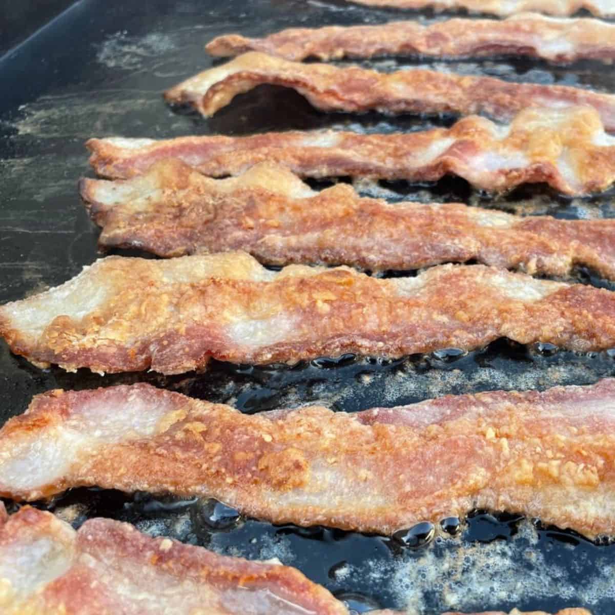 Bacon cooking on a Blackstone griddle