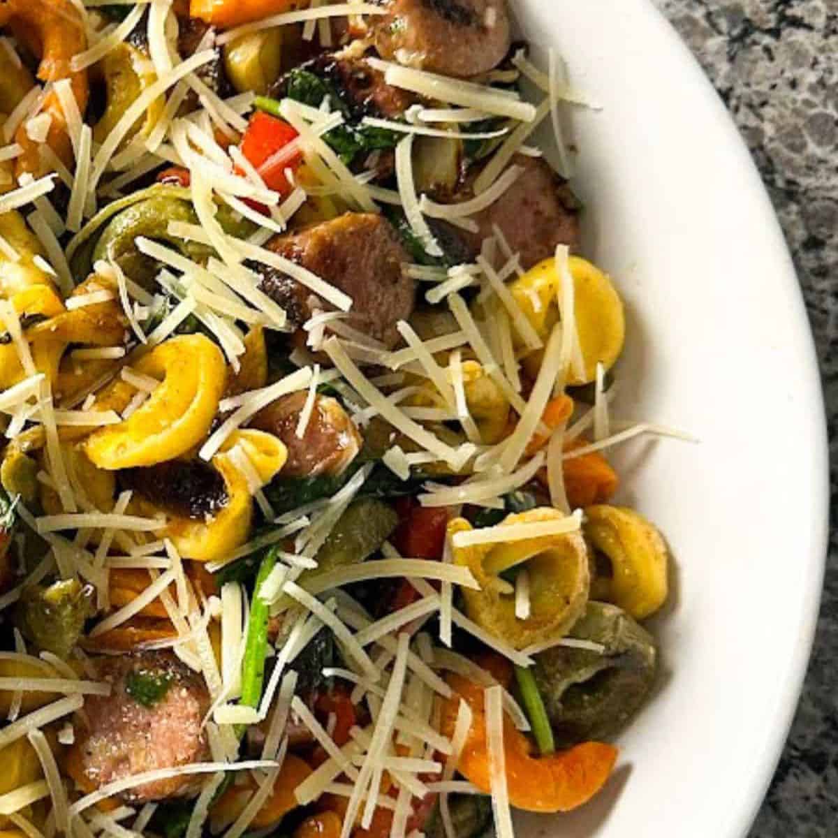 Blackstone tortellini and sausage on a white plate