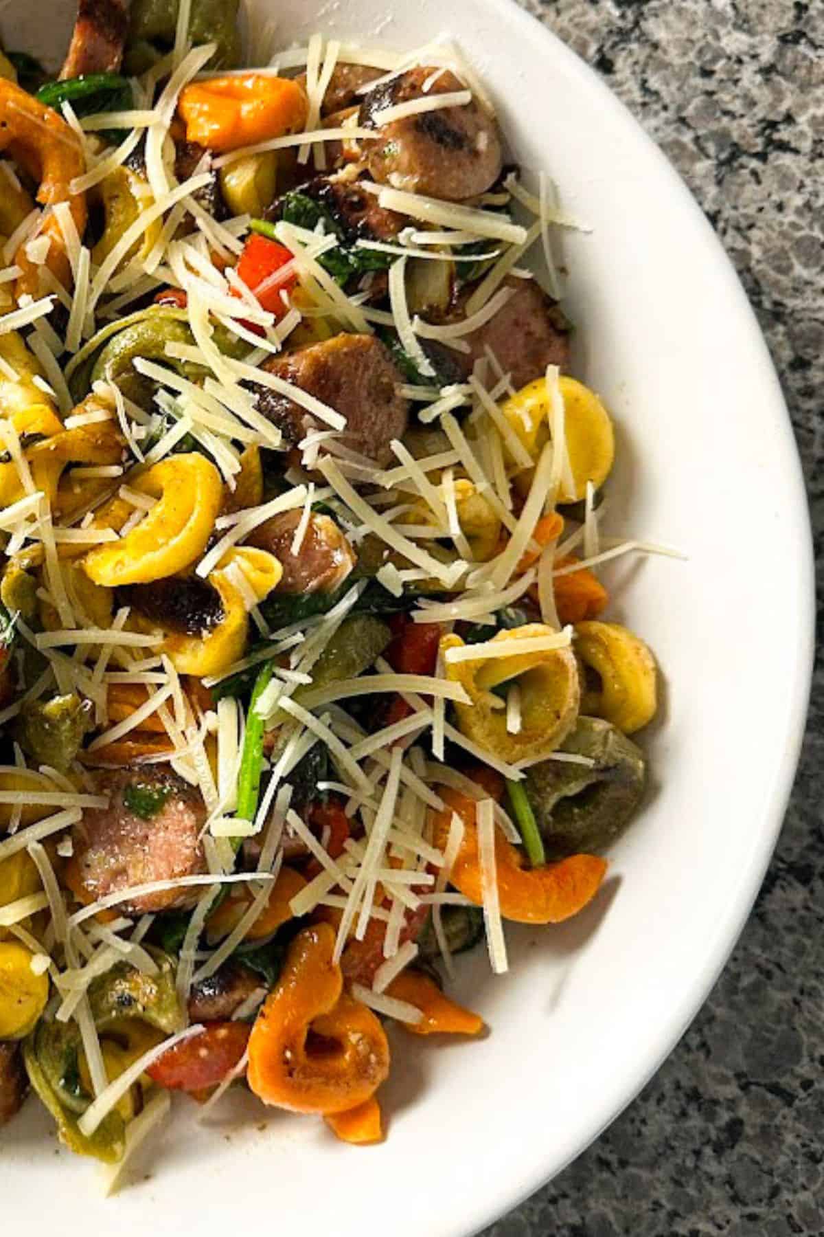 Blackstone tortellini and sausage on a white plate
