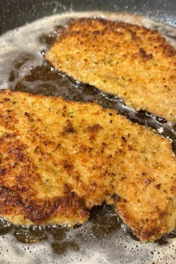 Italian breaded chicken cutlets frying in a pan