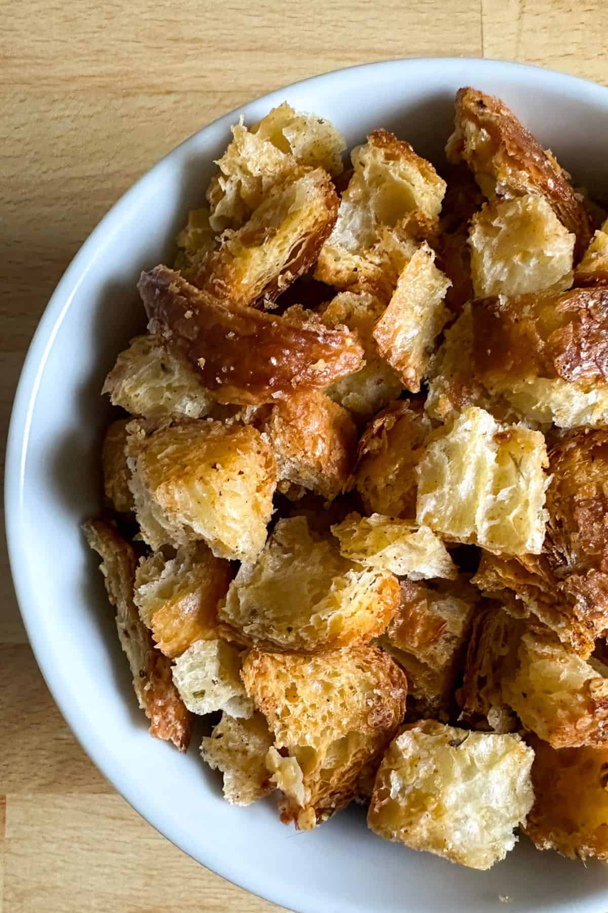 White bowl full of homemade croissant croutons