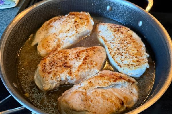 Chicken breast cooking in a pan