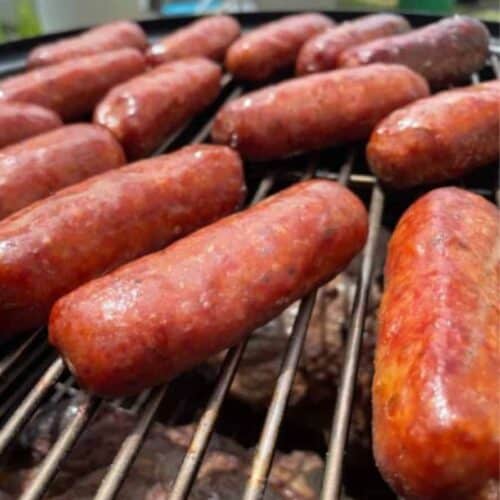 Sweet Italian sausage smoking on a grill