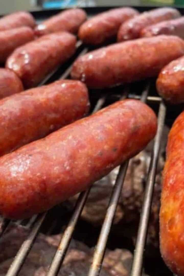 Sweet Italian sausage smoking on a grill