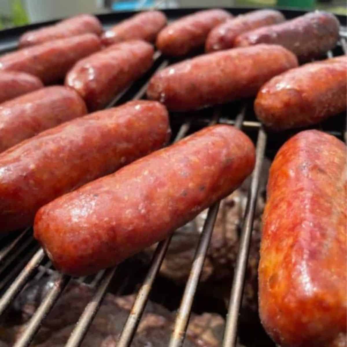 Sweet Italian sausage smoking on a grill