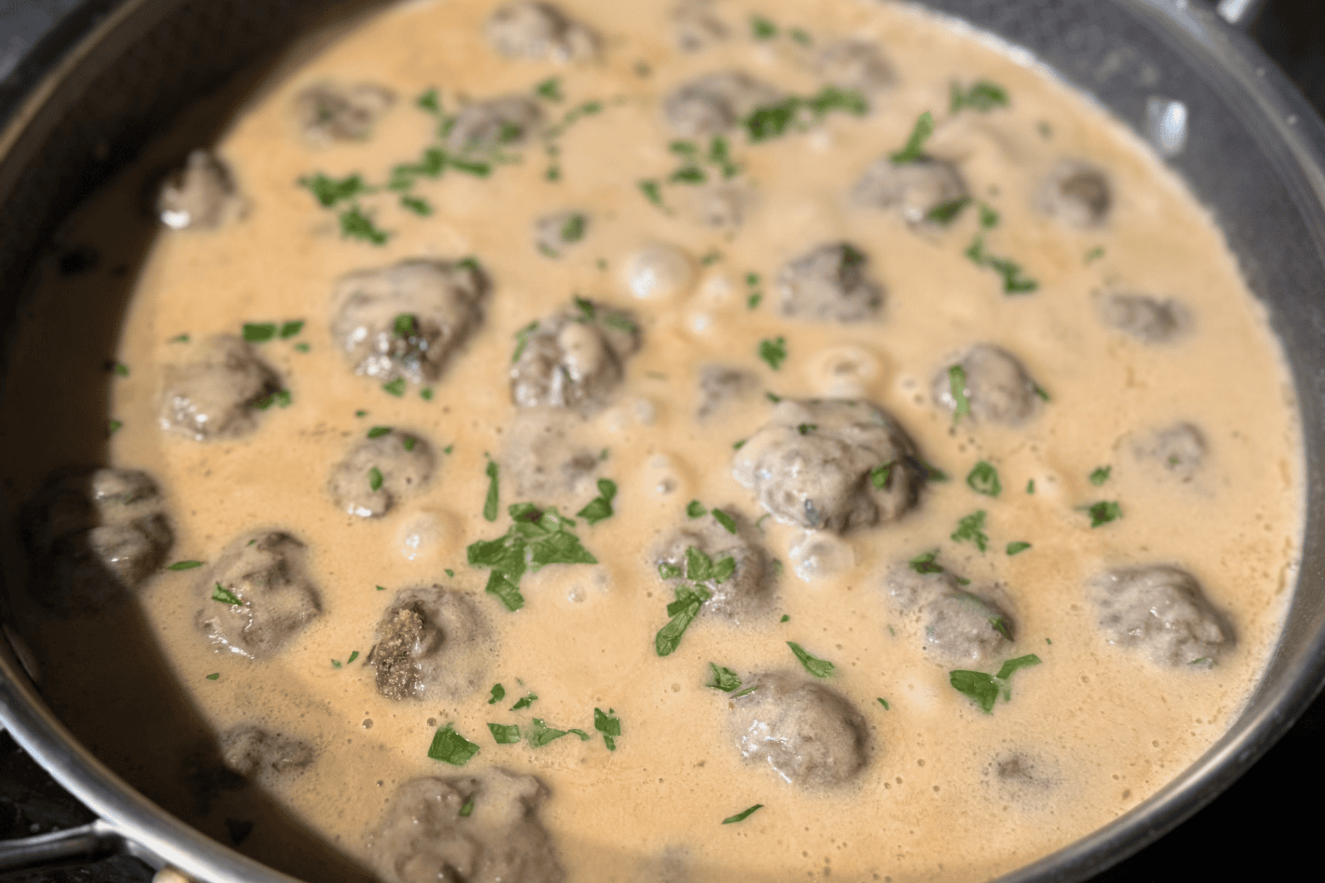 Swedish meatballs simmering in a pan