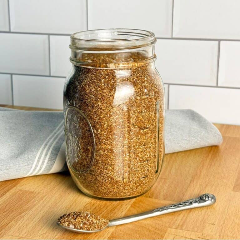A glass jar and spoon of homemade sweet and smoky rub