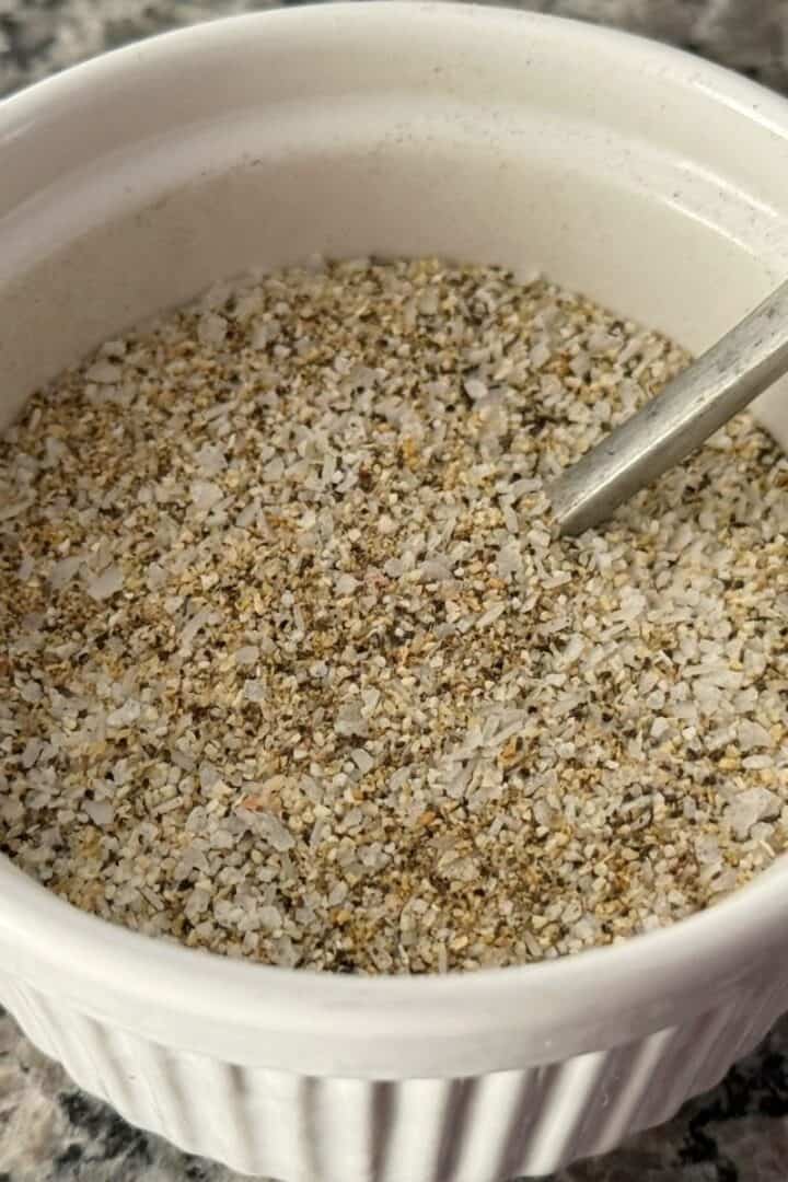 White bowl full of my Core Four blend of seasoning with a silver spoon