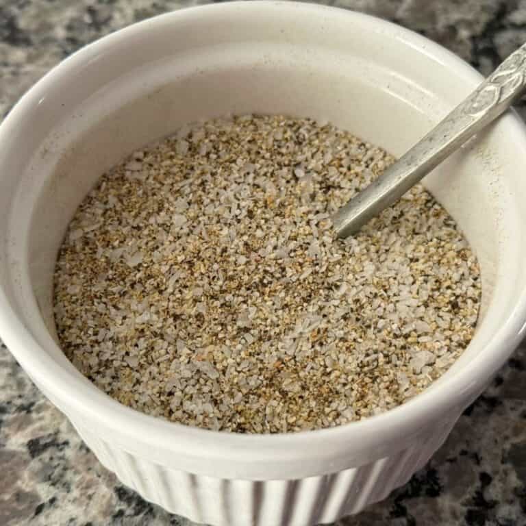 White bowl full of my Core Four blend of seasoning with a silver spoon