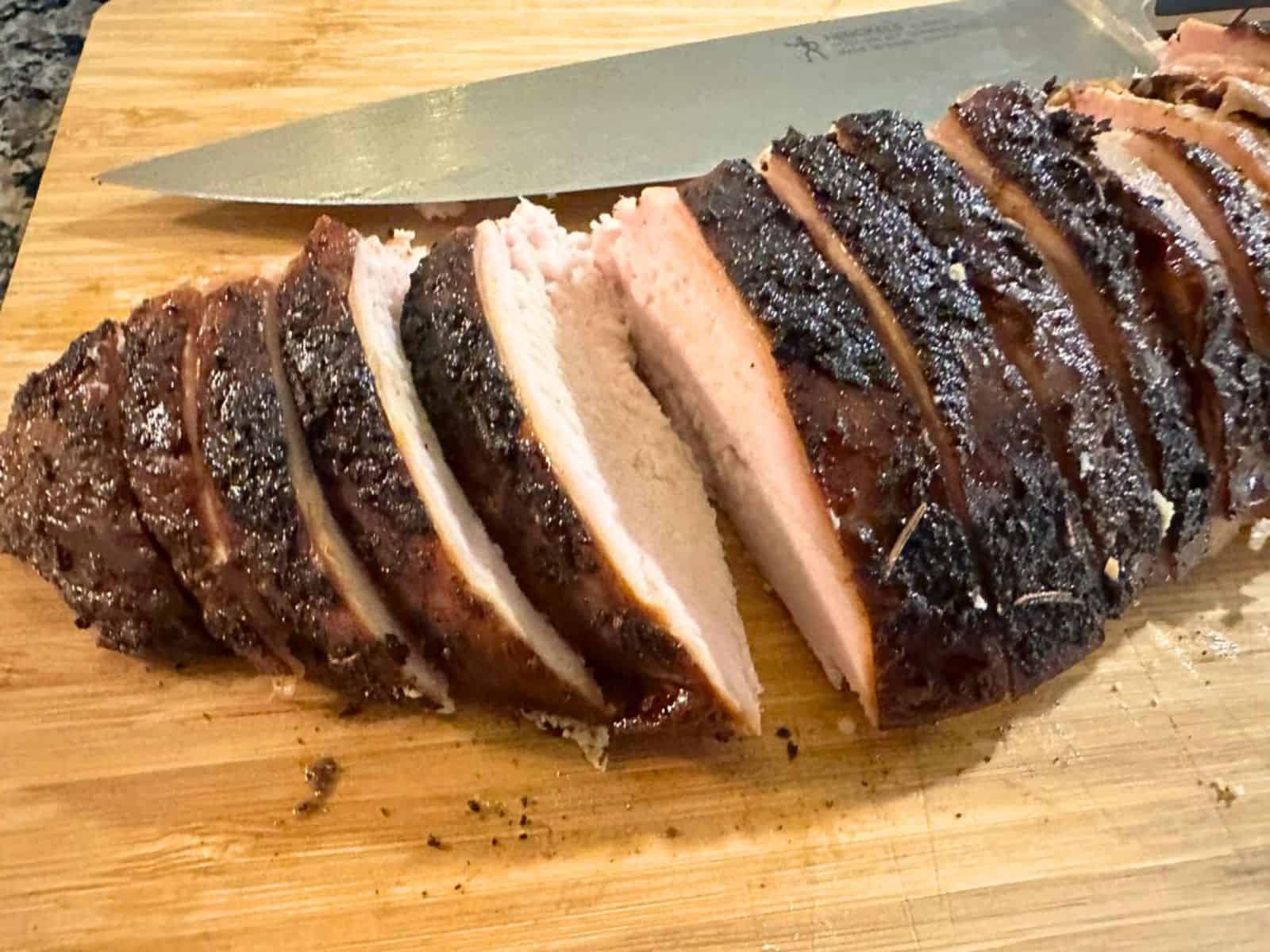 Smoked turkey breast sliced on a cutting board