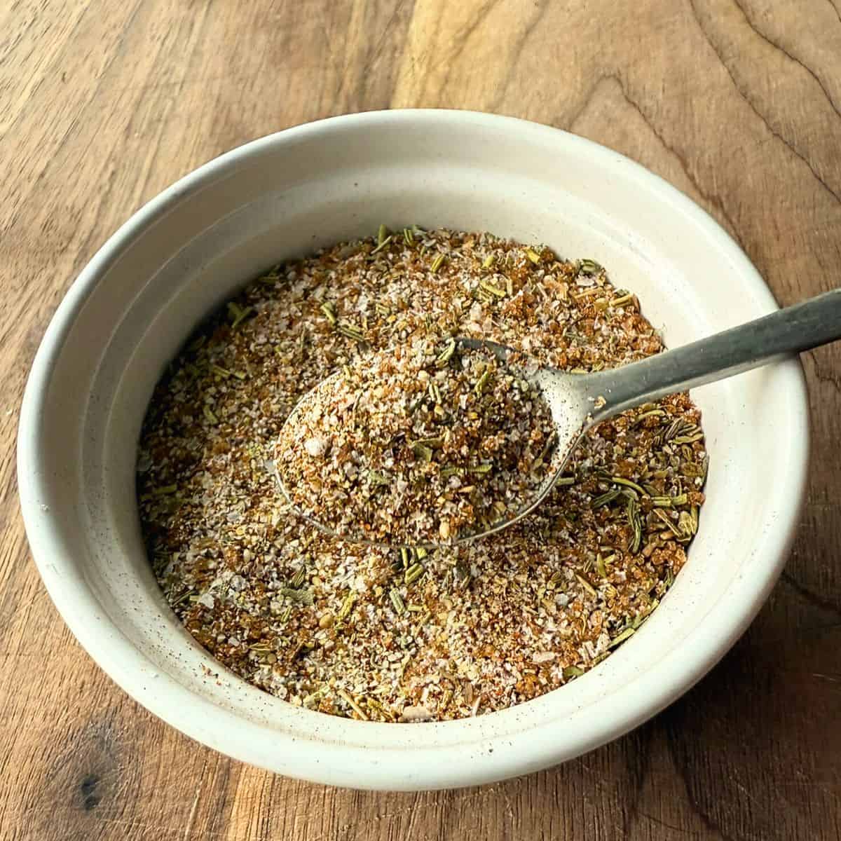 Turkey dry rub seasoning in a small white bowl with a silver spoon