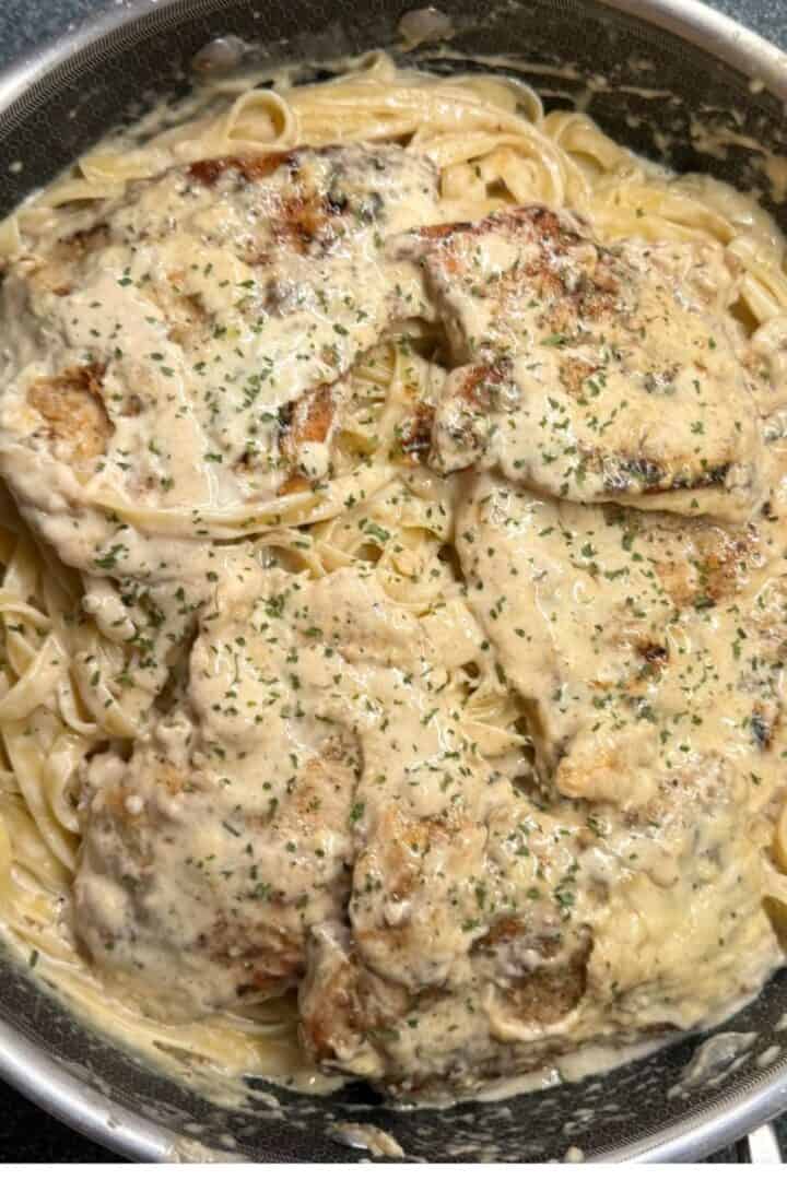 Creamy Garlic Chicken in a pan with fettucine pasta