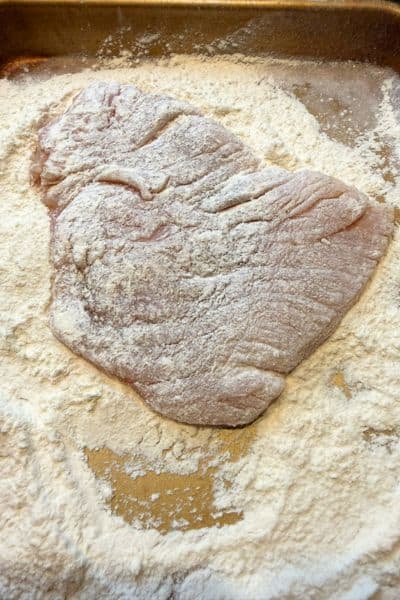 Dredging chicken breast in flour