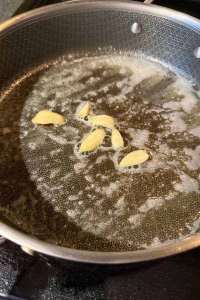 Garlic cloves cooking in melted butter
