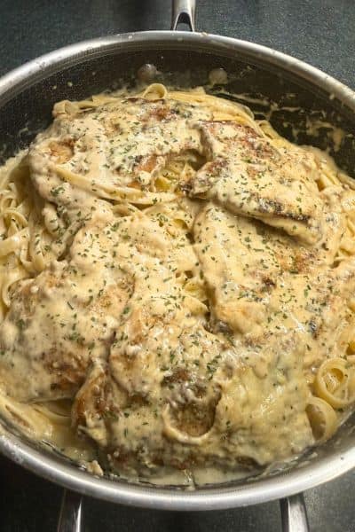 Creamy garlic chicken in a pan with fettucine