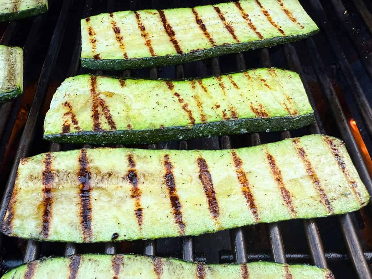 Slices of zucchini cooking on a grill