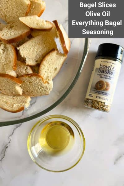 A bowl of bagel slices, a container of everything bagel seasoning, and a small bowl of olive oil