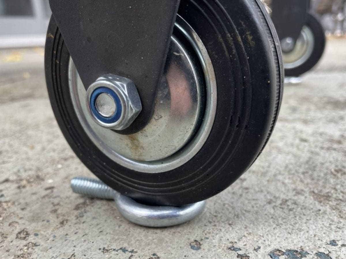 The wheel of a Blackstone griddle sitting on a metal bolt to level it