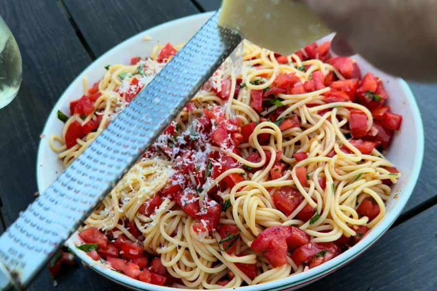 Grating parmesan onto pasta with no-cook tomato sauce